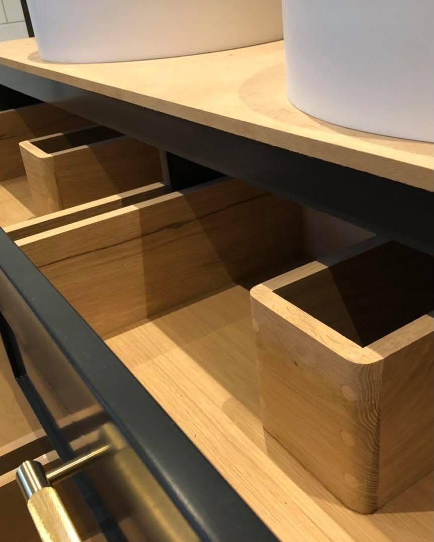 Close-up of wooden drawer interiors in a bespoke painted bathroom vanity
